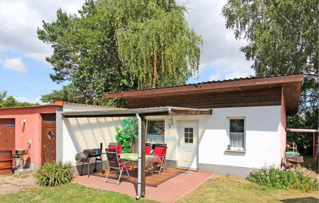 ein kleines weißes Haus mit einem Tisch und Stühlen in der Unterkunft Cozy Home In Waren mritz With Kitchen in Seebad Kölpinsee