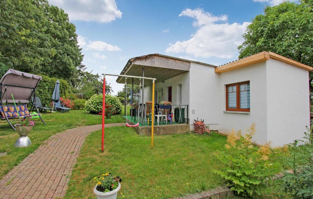 a small white house with a brick driveway at 2 Bedroom Cozy Home In Blankensee Ot Gro Sch in Blankensee