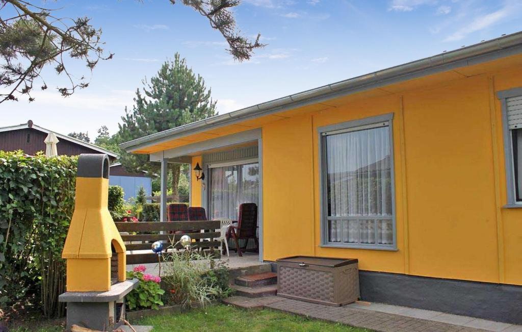 une maison jaune avec un grand fumeur jaune dans la cour dans l'établissement 2 Bedroom Cozy Home In Wesenberg, à Wesenberg