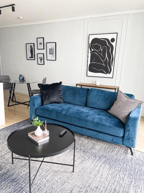 ein blaues Sofa im Wohnzimmer mit einem Tisch in der Unterkunft ERL Ellipse Waterfall. in Midrand