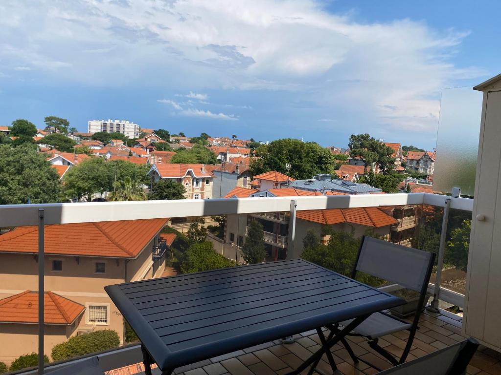 un balcon avec une table et une vue sur une ville dans l'établissement Studio Cabine - Centre Ville, Proche Plage et Casino, Parking Sécurisé, Balcon et Équipements Complets - FR-1-319-495, à Arcachon