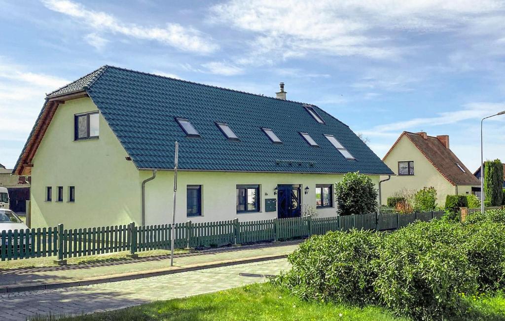 a large white house with a blue roof at Awesome Apartment In Ueckermnde seebad With Wifi in Neuendorf