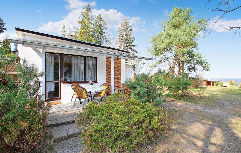 ein kleines Haus mit einem Tisch und Stühlen auf einer Terrasse in der Unterkunft Beautiful Home In Ueckermnde Ot Bellin With Lake View in Bellin