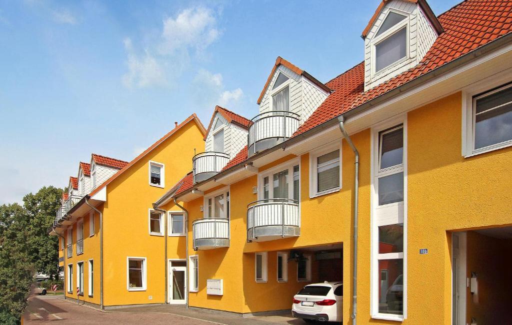 a row of yellow buildings with a car parked in front at Gorgeous Apartment In Neubrandenburg With Kitchen in Neubrandenburg