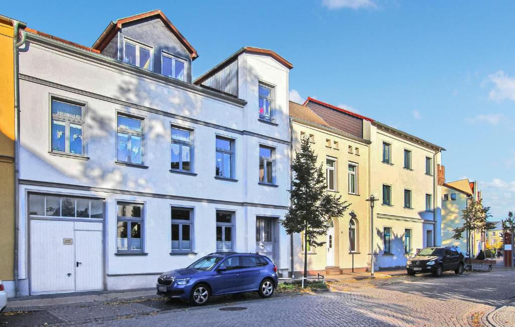 un coche azul estacionado frente a un edificio blanco en Cozy Home In Waren mritz With Wifi en Waren