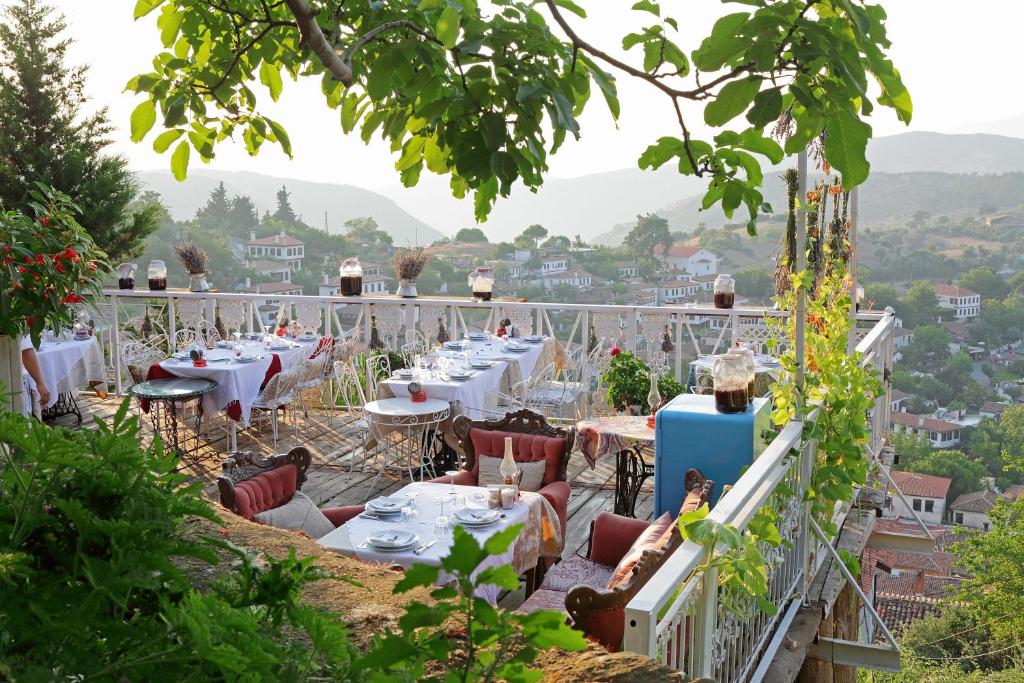 a restaurant with tables and chairs on a balcony at Nisanyan Hotel in Selçuk