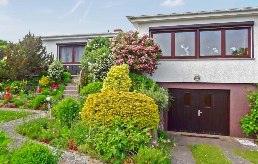 une maison avec un garage et quelques buissons et fleurs dans l'établissement Nice Home In Rbel-mritz With Kitchen, à Röbel