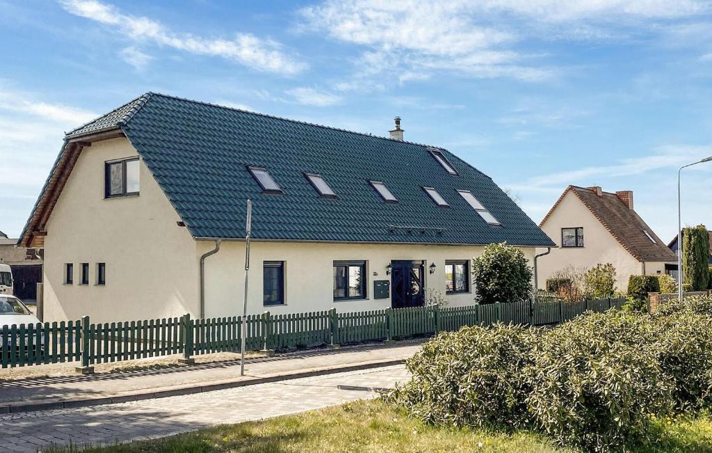 a large white house with a black roof at Pet Friendly Apartment In Ueckermnde seebad With Kitchen in Neuendorf