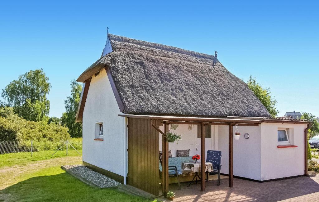 a small white cottage with a thatched roof at 1 Bedroom Awesome Home In Fuhlendorf in Fuhlendorf