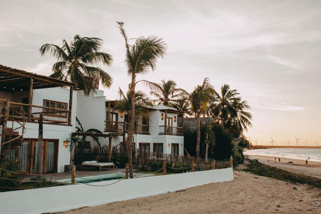 ein Haus am Strand mit Palmen in der Unterkunft Villa Mango Beach Houses in Praia de Moitas