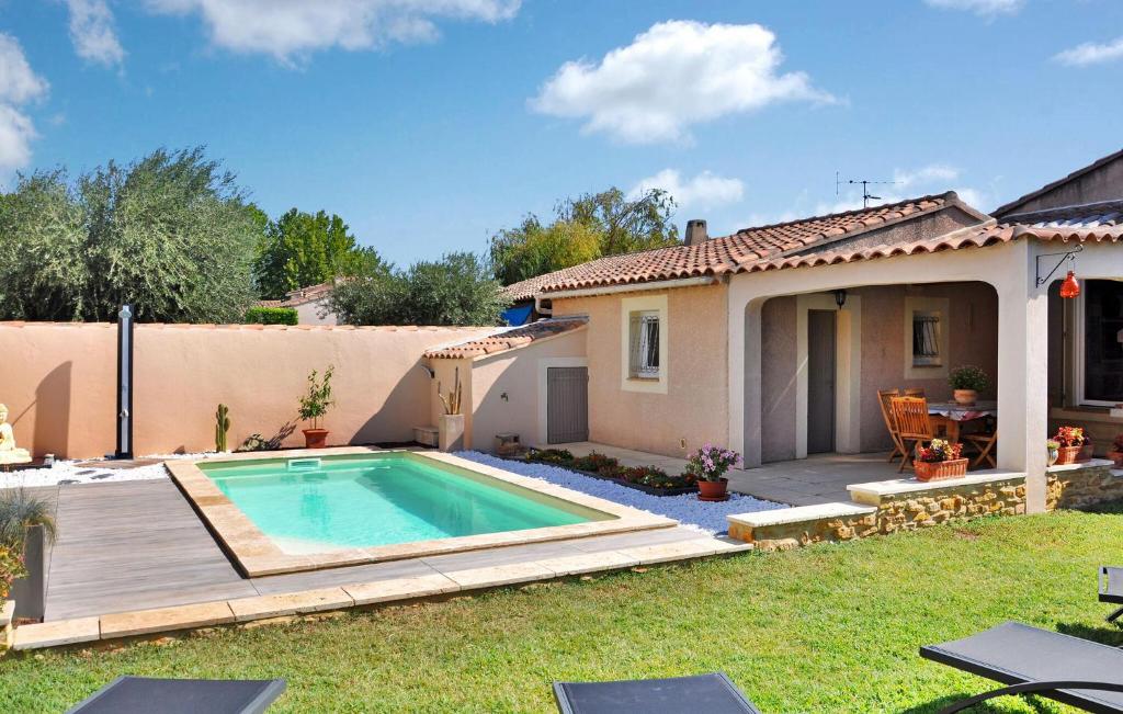 een achtertuin met een zwembad en een huis bij La Villa De Sacha in Vedène