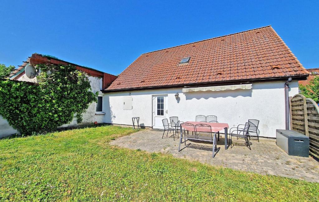 a white house with a table and chairs in the yard at 3 Bedroom Cozy Home In Blankensee Ot Watzkend in Blankensee
