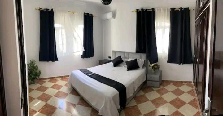 sypialnia z dużym łóżkiem z czarnymi zasłonami w obiekcie Chambres Maya w mieście Ksar es-Seghir