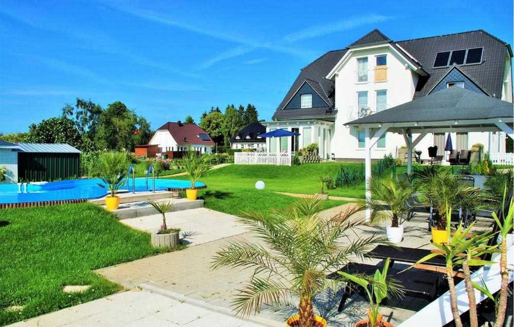 a house with a swimming pool and a yard with palm trees at Nice Apartment In Neppermin-usedom With Kitchen in Neppermin