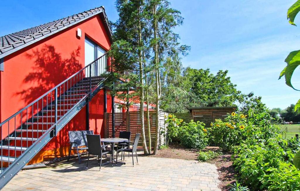 een rood huis met een patio en een tafel en stoelen bij 1 Bedroom Beautiful Apartment In Grnow in Blankensee
