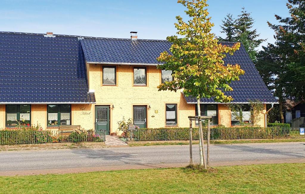 a house with a blue roof and a tree at 1 Bedroom Nice Apartment In Raduhn in Raduhn