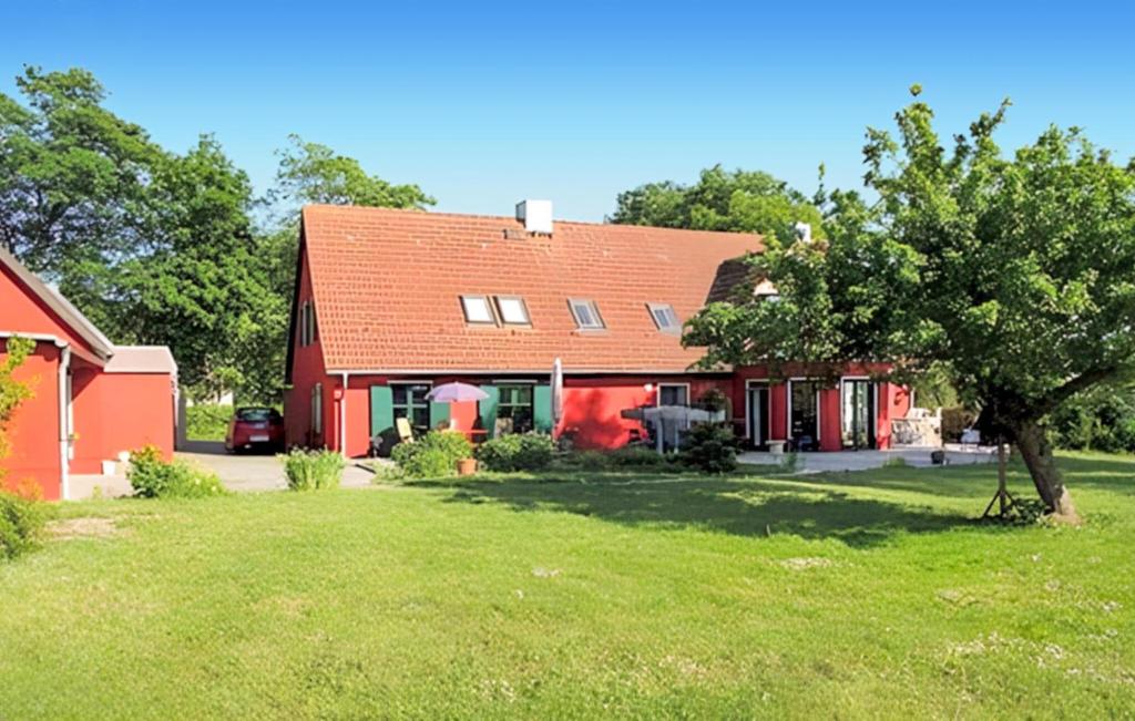 a red house with a tree in the yard at Beautiful Home In Klpin With Kitchen in Kölpin