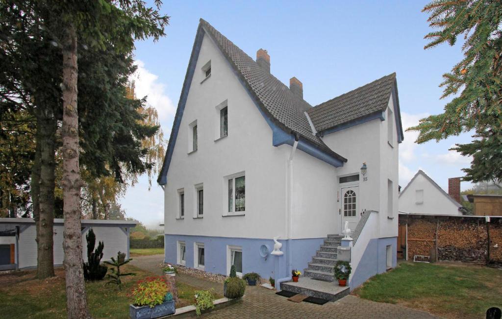 uma casa branca com um telhado azul em Stunning Apartment In Heringsdorf seebad With Kitchen em Bansin
