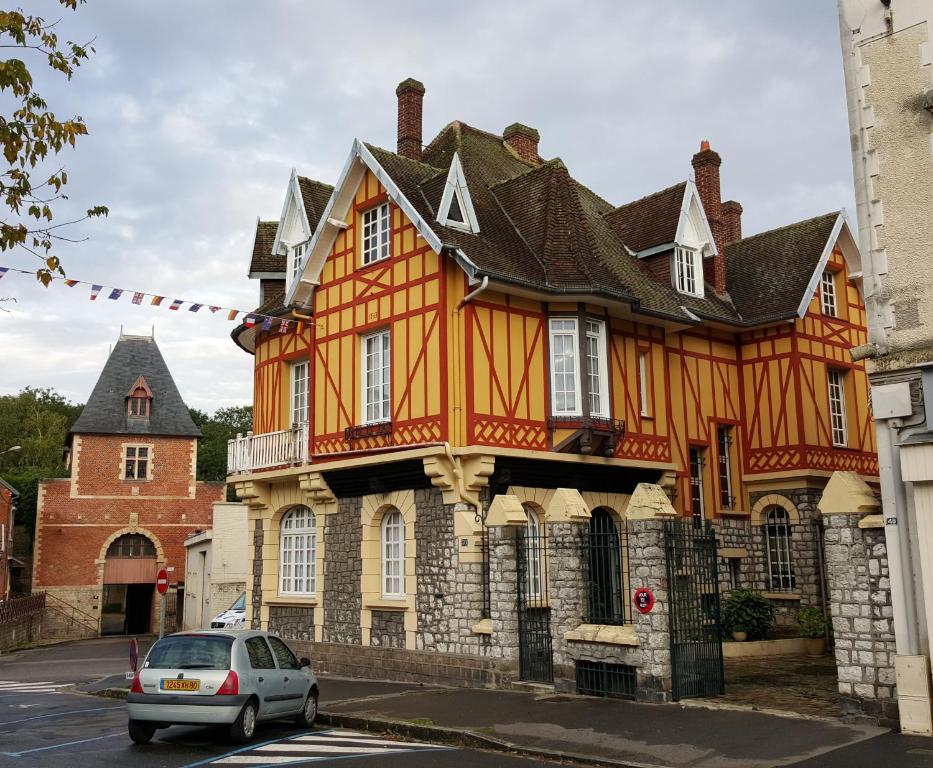 ein orangenes Gebäude mit einem davor geparkt in der Unterkunft La Porte De Bretagne in Péronne