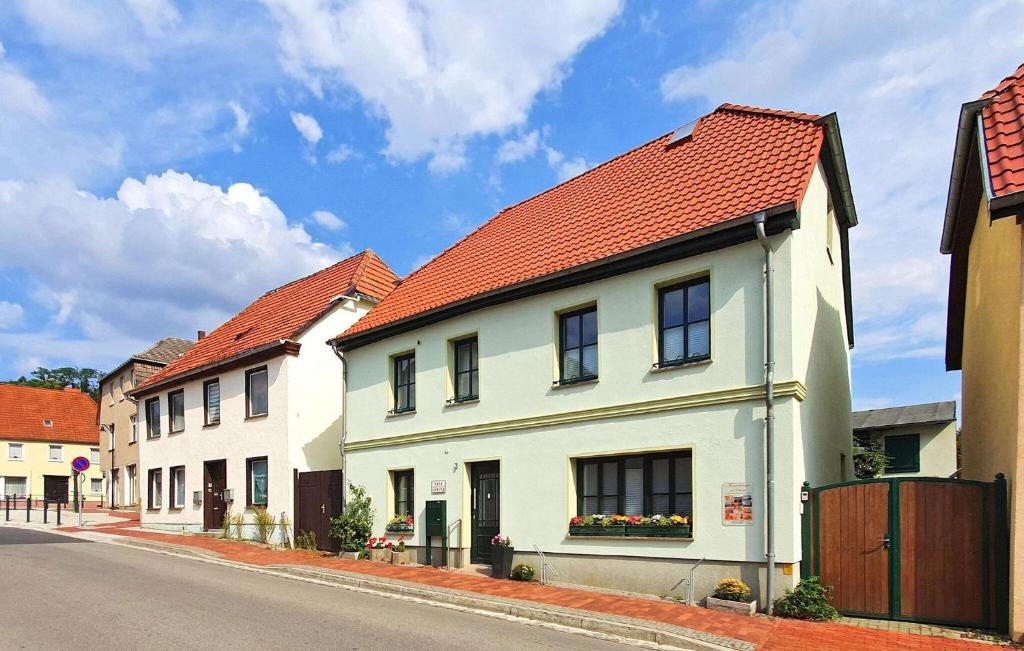uma casa branca com um telhado laranja numa rua em Ferienwohnung Mit Charme em Burg Stargard