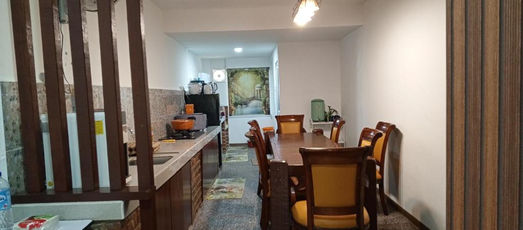Un comedor con una mesa larga y sillas. en HOMESTAY DARULFALAH -Private Pool, en Kuala Terengganu