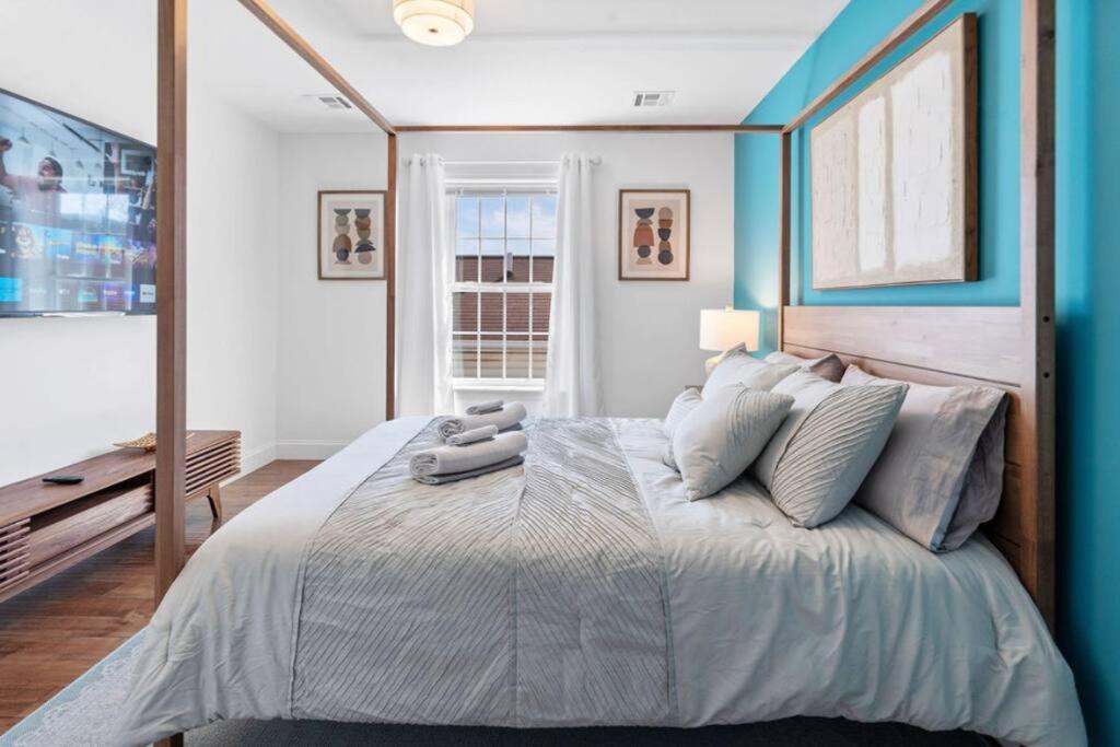 um quarto com uma cama grande e paredes azuis em Cityscape em Newark