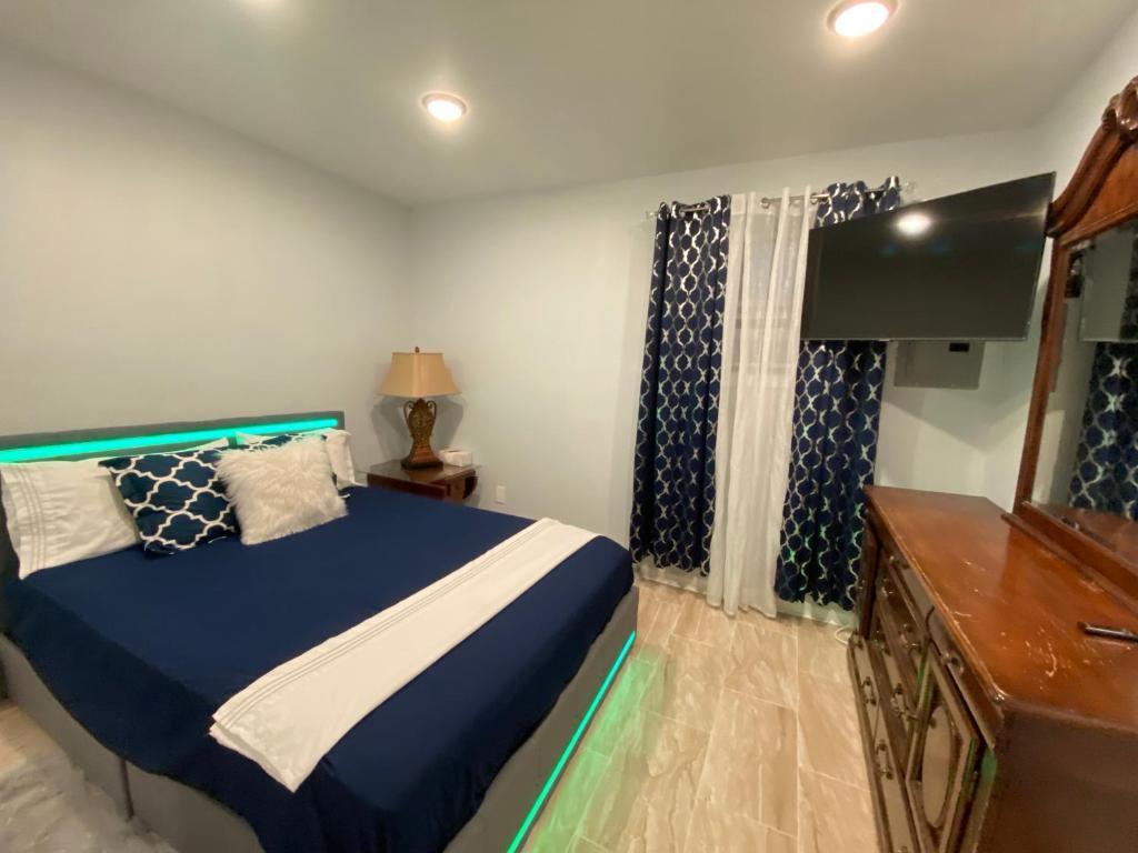 Un dormitorio con una cama azul y blanca y un tocador en Nice 2 Bedrooms apartment at 15 minutes to New York excellent bus transportation, en North Bergen