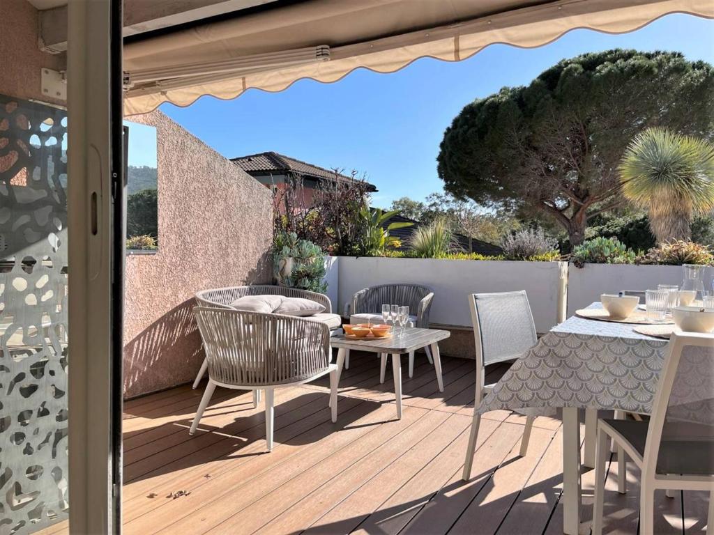 un patio avec une table et des chaises sur une terrasse dans l'établissement Charmant T2 climatisé avec piscine, terrasse, parking et Wi-Fi - 4 couchages, Le Lavandou - FR-1-251-540, au Lavandou