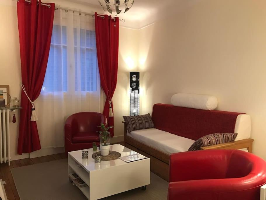 ein Wohnzimmer mit einem Sofa und roten Stühlen in der Unterkunft Cosy Home in Paris 15 in Paris