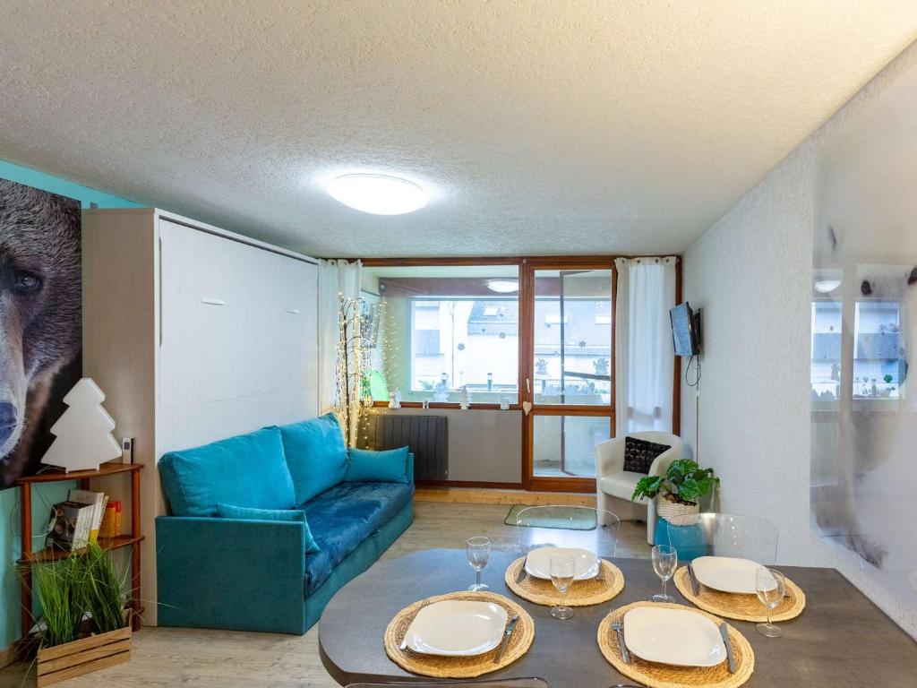 un salon avec un canapé bleu et une table dans l'établissement Studio 4 pers. avec garage, balcon et navette, proche commerces et téléphérique à Saint-Lary-Soulan - FR-1-296-497, à Saint-Lary-Soulan