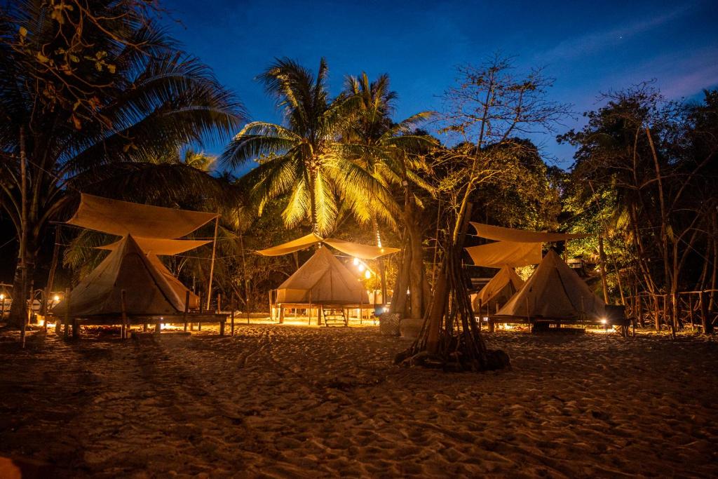 - un groupe de tentes sur une plage la nuit dans l'établissement Long Beach Camp, aux Îles Perhentian