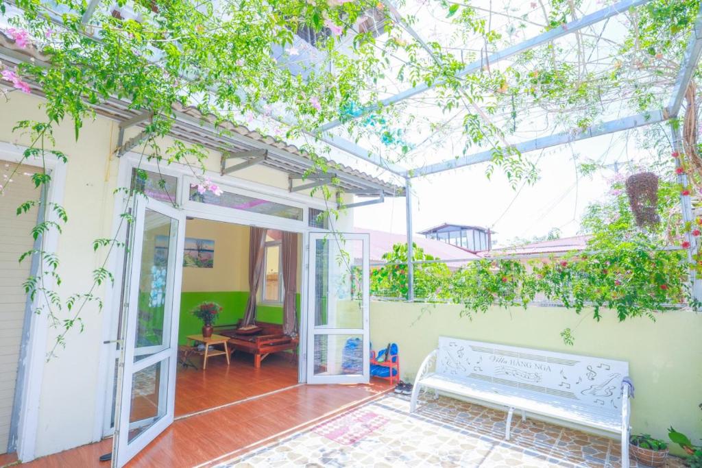 a conservatory with a white bench and some plants at Villa Hang Nga 2 in Da Lat