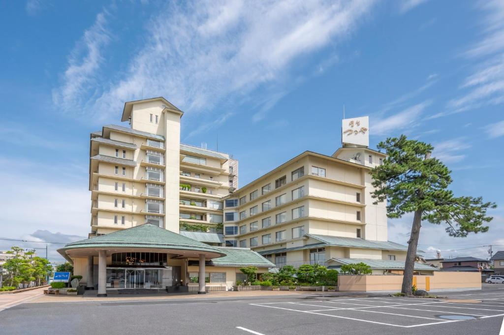 ein Gebäude mit einem Uhrturm neben einem Parkplatz in der Unterkunft Kaike Tsuruya in Yonago