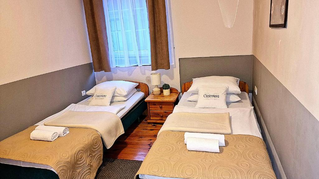 a room with two beds with towels on them at Starówka Boutique Hostel Cieszyn Centrum in Cieszyn
