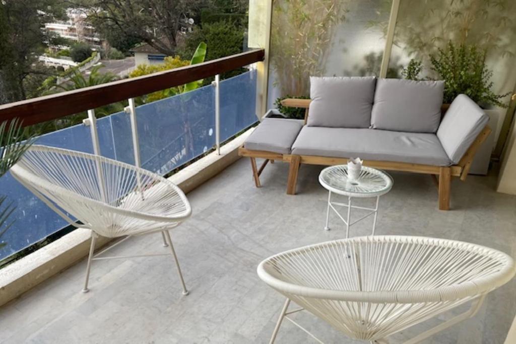 d'une terrasse avec un canapé et des chaises sur un balcon. dans l'établissement Apartment with terrace in Le Cannet Colline, au Cannet