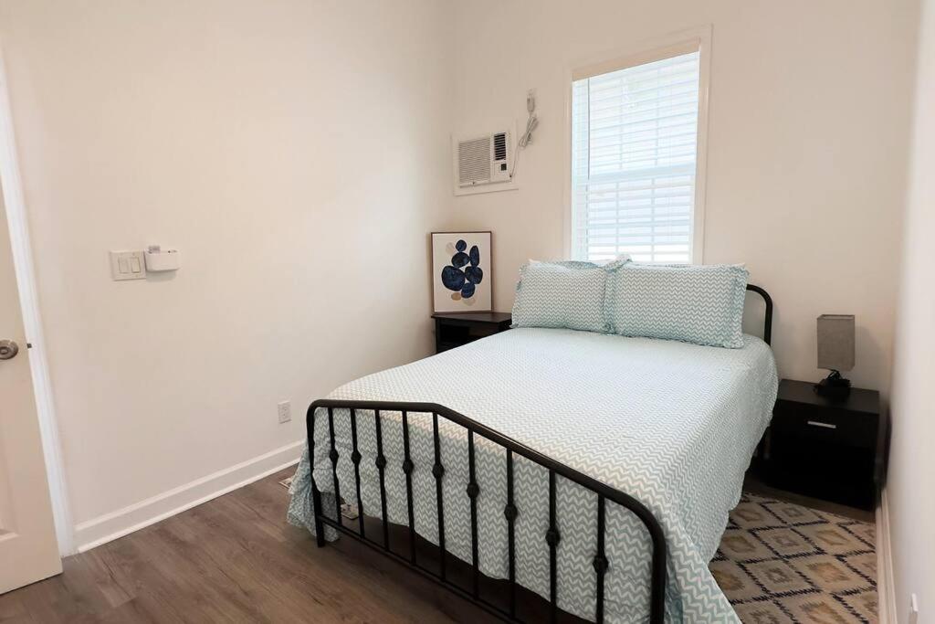ニューオーリンズにあるCharming 2BR! Close to FQ & Bourbon st.の青い枕と窓のあるベッドのある寝室