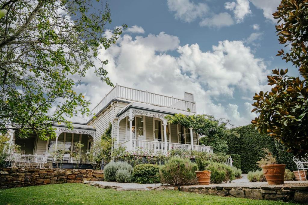 a white house with a garden at Lake Daylesford Country House in Daylesford