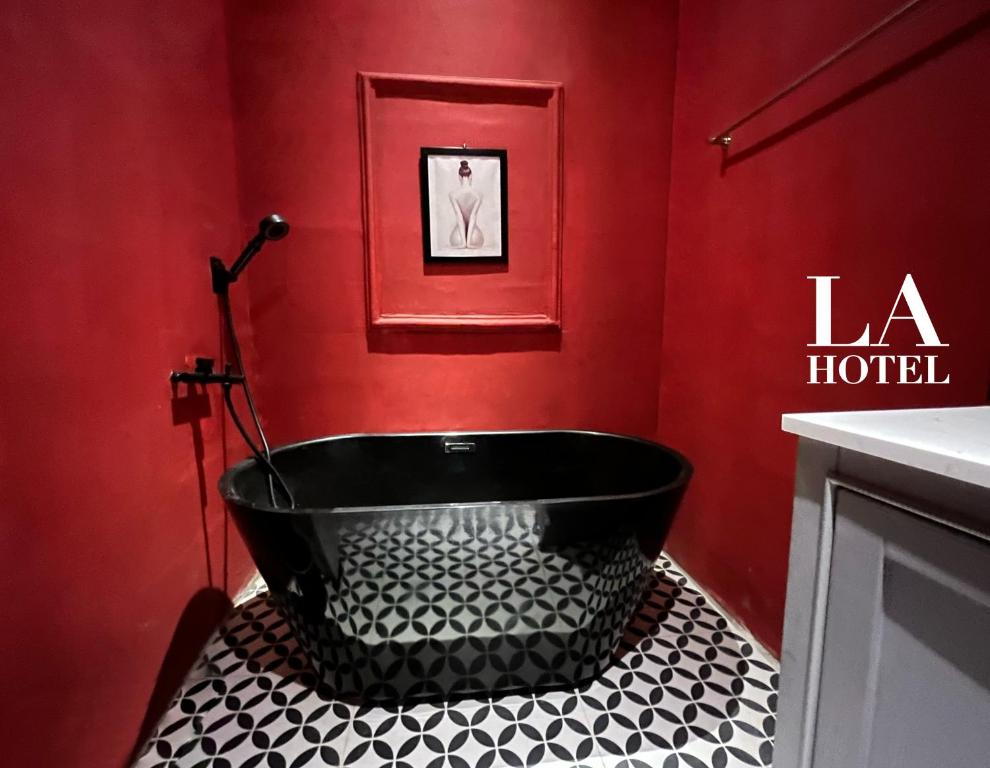 uma casa de banho com uma banheira preta numa parede vermelha em La Hotel em Trung An