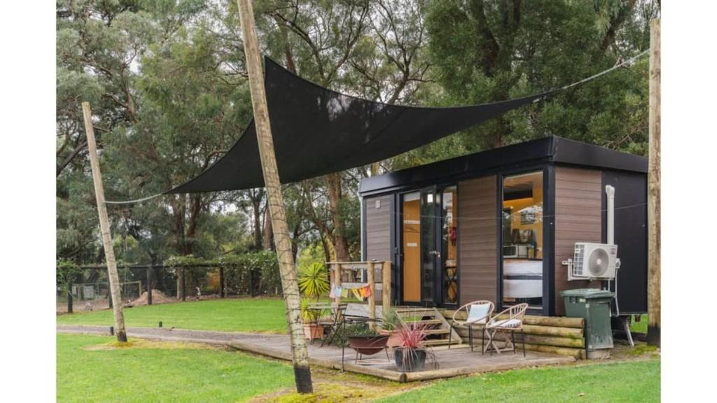 a black canopy over a tiny house in a park at The Junction in Yarra Junction