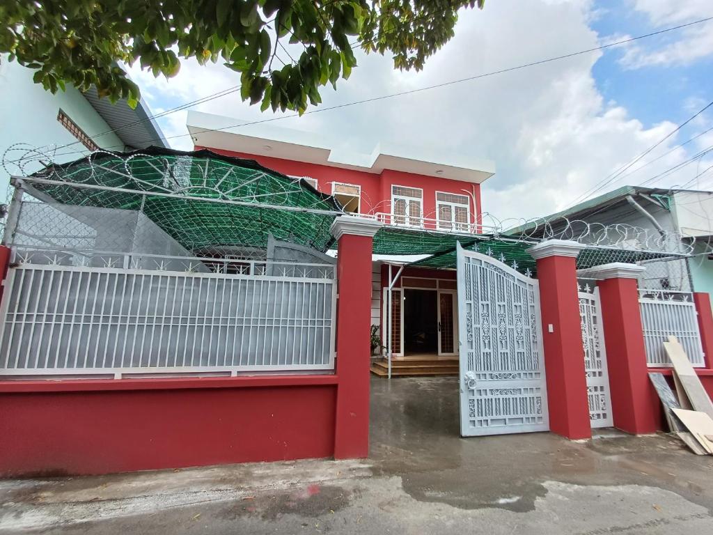 a red house with a white fence in front of it at REDHOME DORM in Ho Chi Minh City
