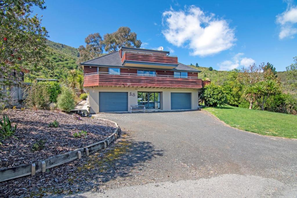 a house on a hill with a driveway at Waimarama Hideaway - Waikawa Holiday Home in Waikawa
