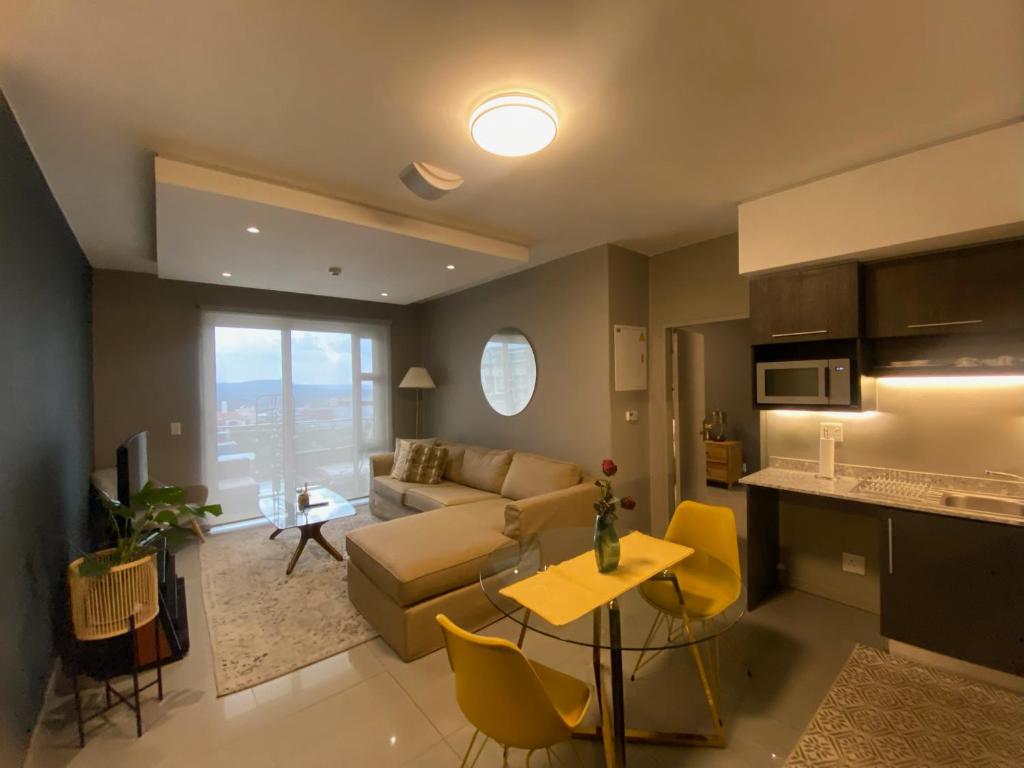 a living room with a couch and a table at Luxurious 2 Bed @ The Tyrwhitt in Johannesburg