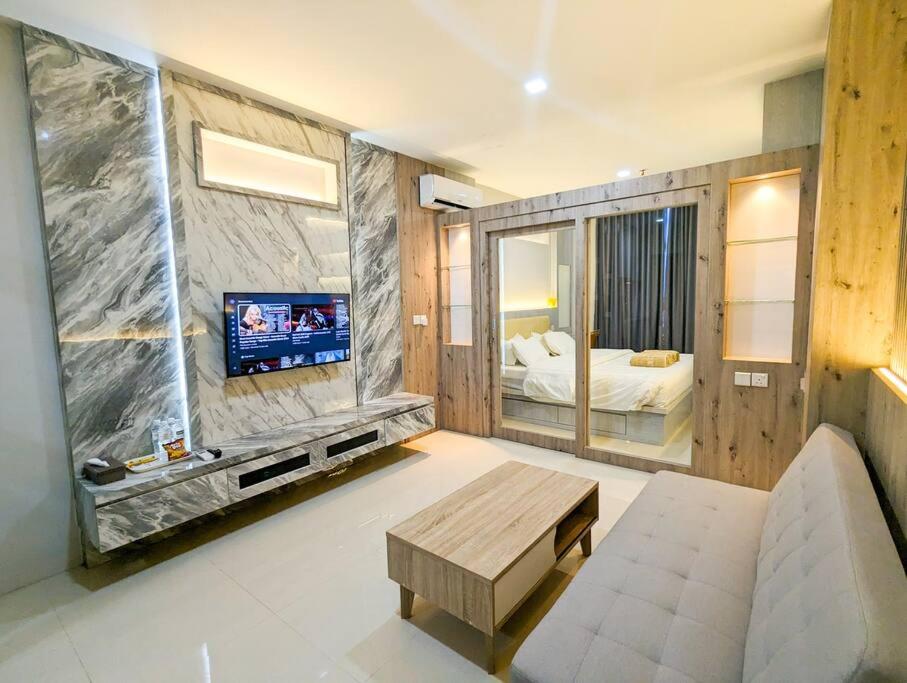 a living room with a couch and a tv at Lovina 19-16 at Formosa Residence in Jodoh