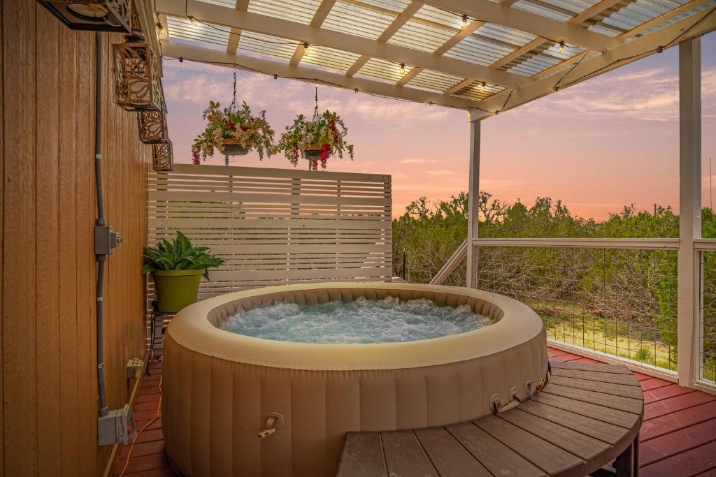 a hot tub on a deck with a pergola at Hill Country Memories in Kerrville