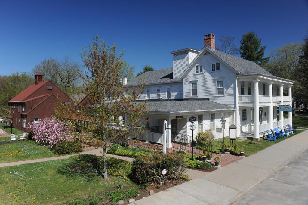 a large white house with a red house at Deerfield Inn in Deerfield