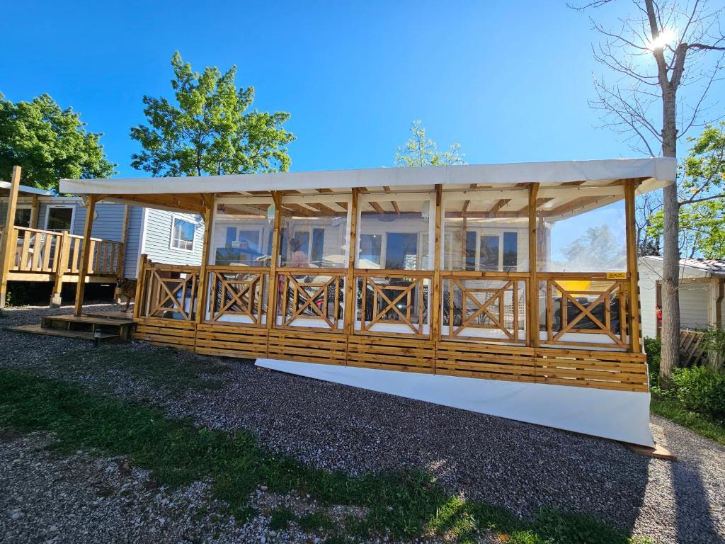 a large wooden pavilion with a roof at Mobil-Home Le Bosc 5 personnes in Le Bosc