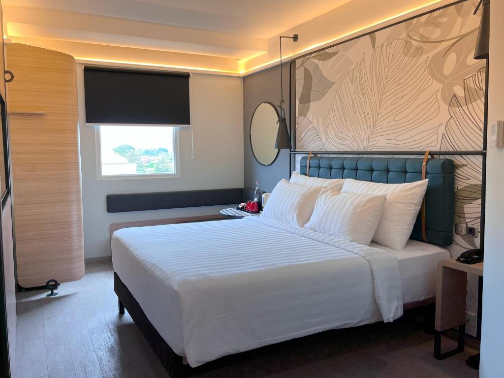 Postel nebo postele na pokoji v ubytování Luminor Hotel Legian Seminyak - Bali