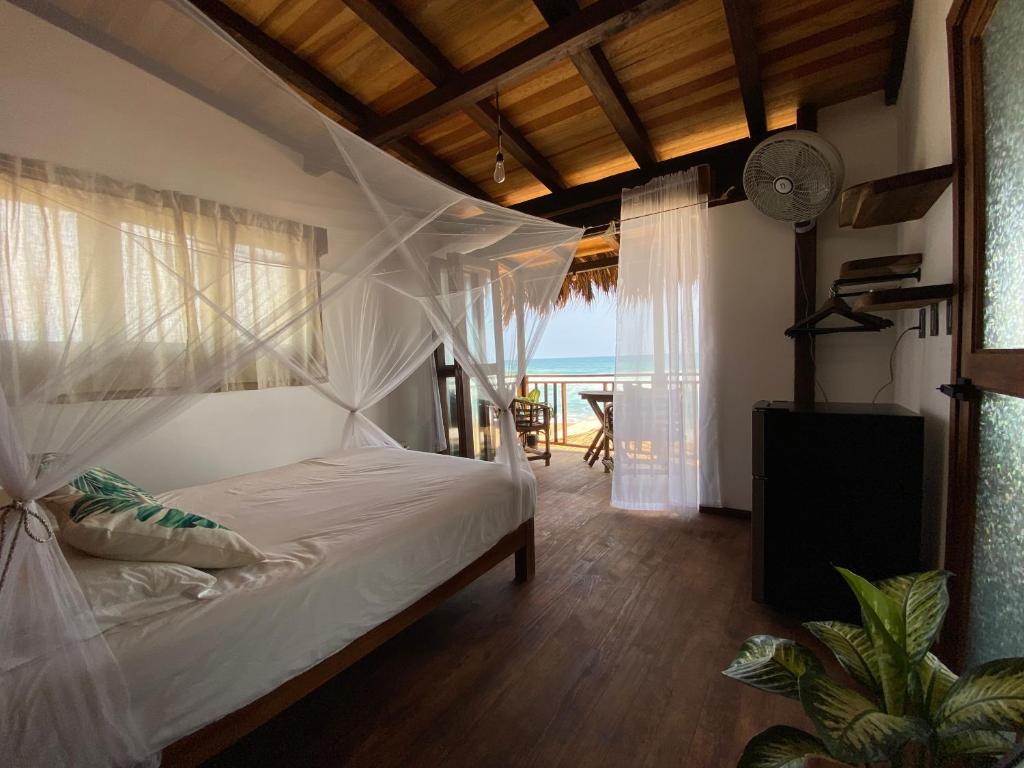 a bedroom with a bed with a view of the ocean at CAFE MAYA in Zipolite
