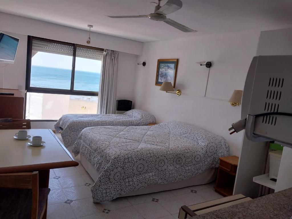 a hotel room with two beds and a window at Mirador Azul Apart, 3 A,B,C in Las Grutas