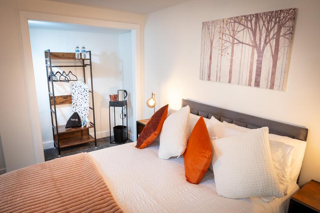 1 dormitorio con 1 cama con almohadas de color naranja y blanco en Kings Arms Suites - Luxury Double - Waterfall Shower - Self Check In, en Whitehaven